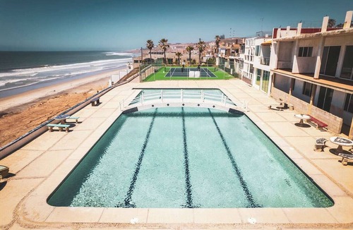 San Antonio del Mar Apartment | A bright, colorful escape just 3 blocks from the ocean in San Antonio del Mar. Sage-green walls and breezy teal curtains set a laid-back coastal mood, with a comfy queen bed, sofa bed, and full kitchen. Shared laundry available in the garage area.