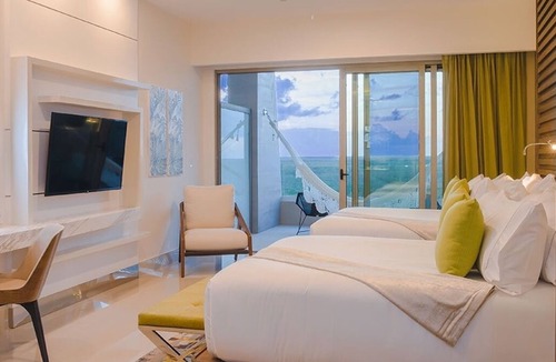 Punta Sam Resort | Cozy 588 sq ft suite with balcony, king/queen beds, and chic modern comforts.