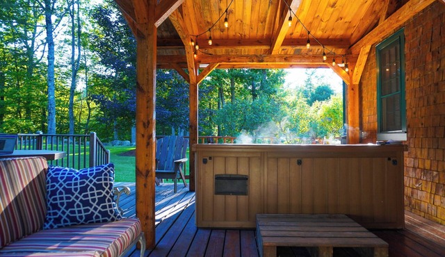 Central Escape is a spacious Lakes Region retreat just 5 minutes from downtown Meredith, less than a mile to Squam Lake and 20 minutes to concerts at the Bank of New Hampshire Pavilion. Enjoy the private year-round hot tub, fire pit, yard games! in Holderness